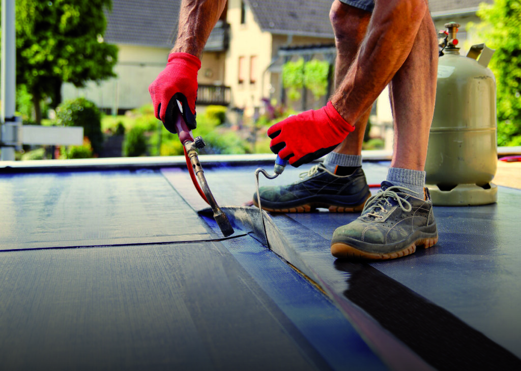 Erfahrener Mitarbeiter von Hanse Dachbau bei der Flachdachsanierung in Lüneburg. Präzise Arbeit und Fachkenntnisse für zuverlässige Bauqualität.